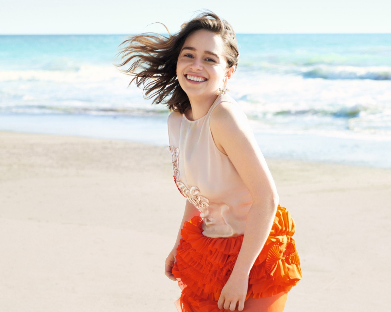 Улыбающаяся девушка, актриса Эмилия Кларк на фоне моря