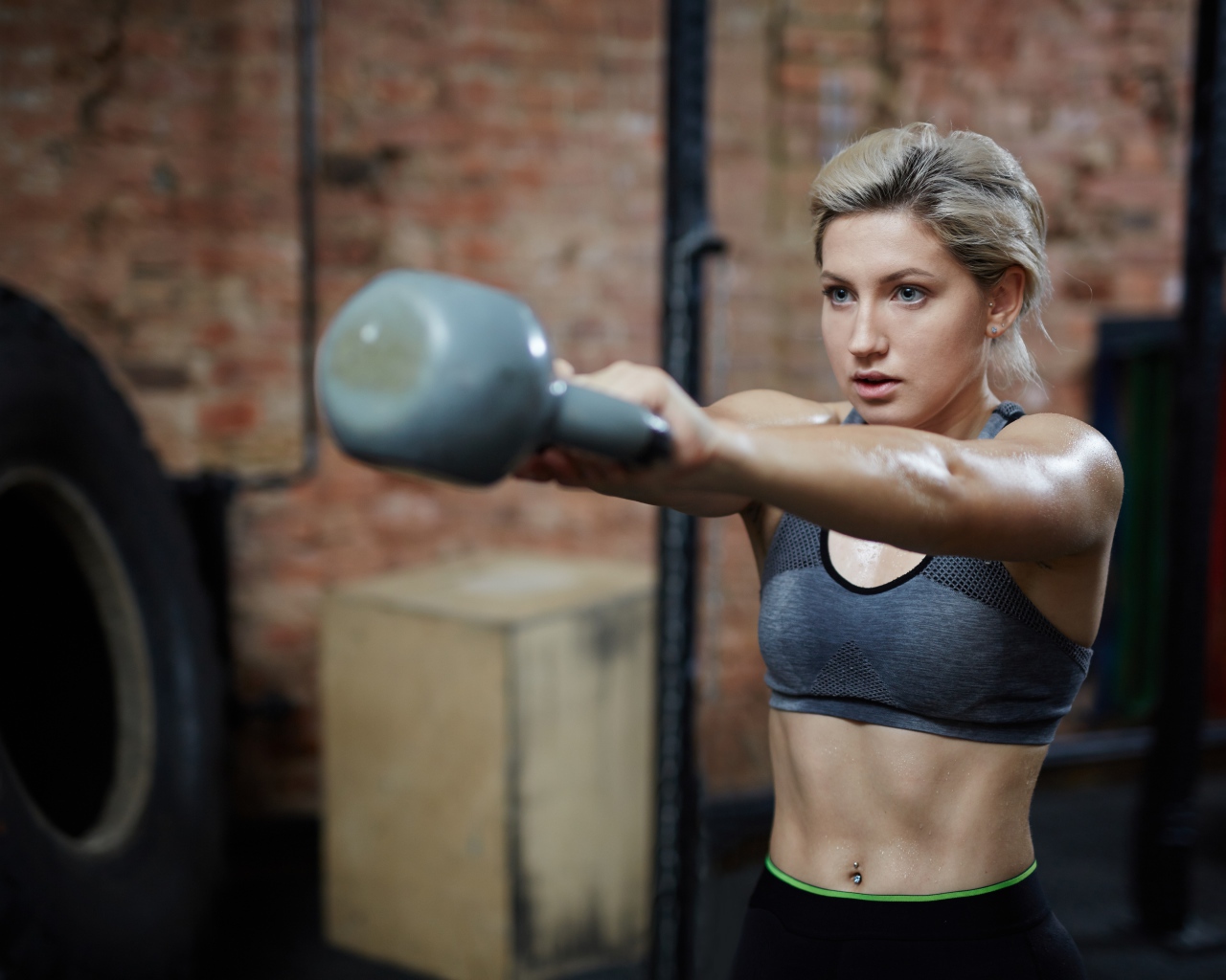 Спортивная девушка с гантелей в спортзале