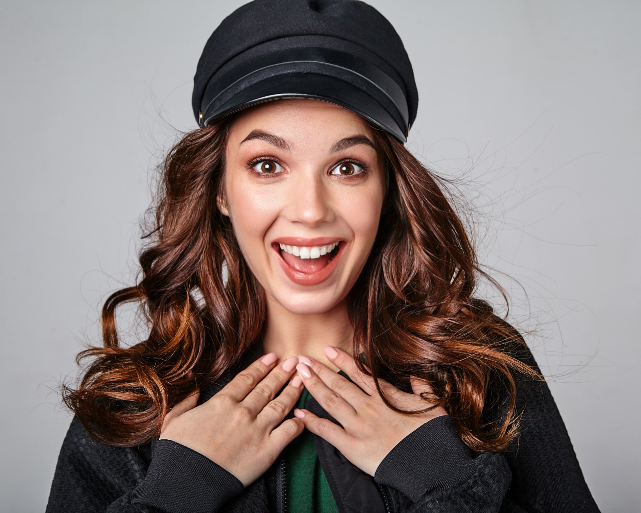 Удивленная кареглазая девушка в черной кепке