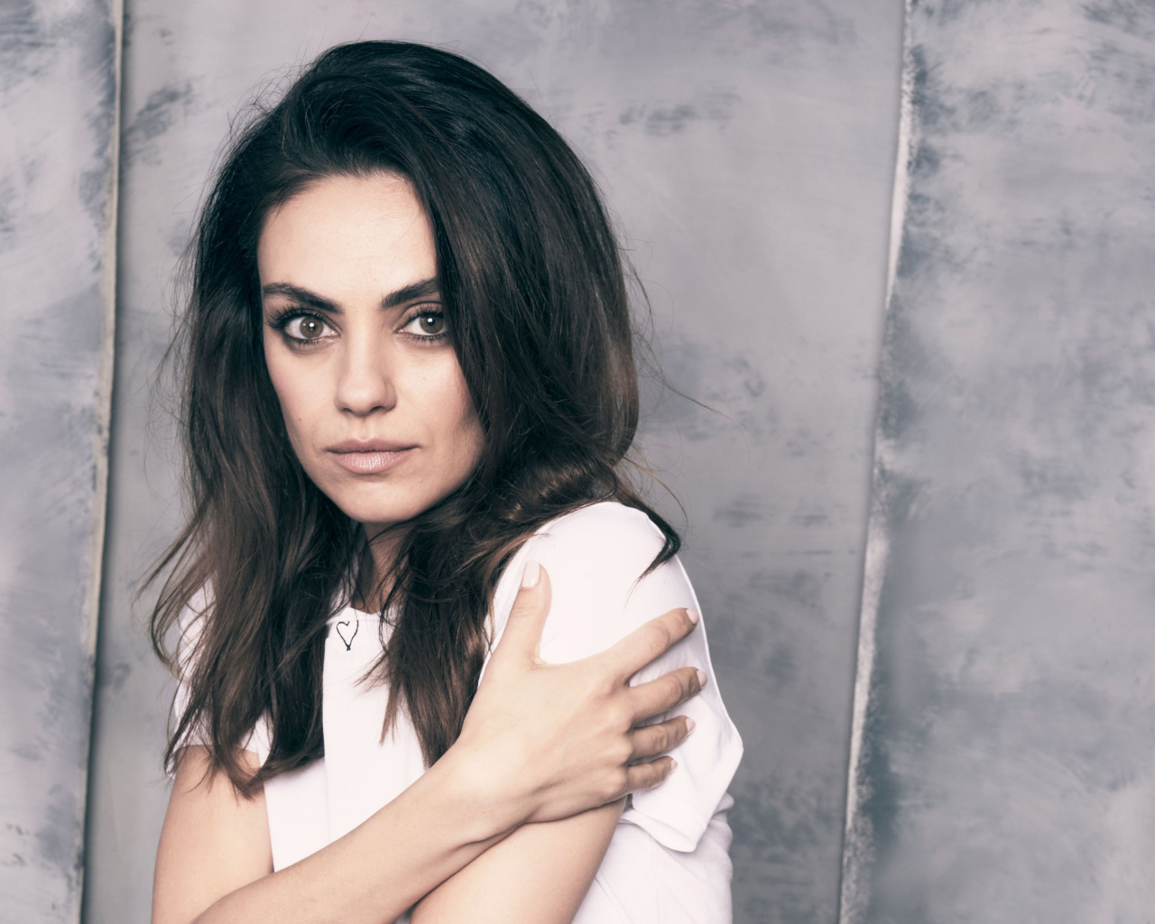 Нежная девушка, актриса Мила Кунис на сером фоне