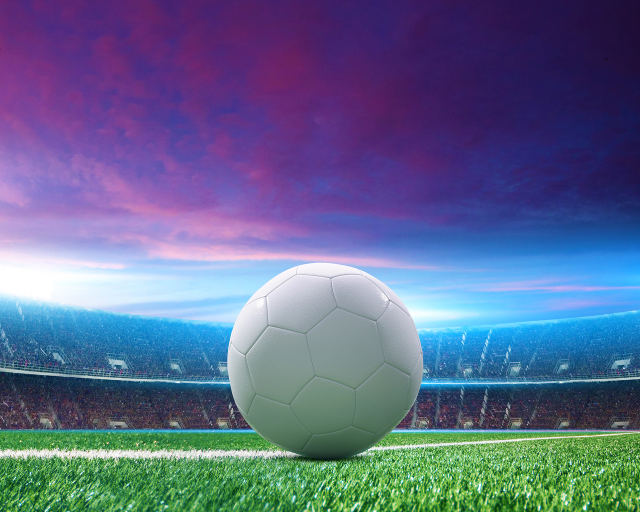 Белый футбольный мяч на зеленой траве на стадионе 