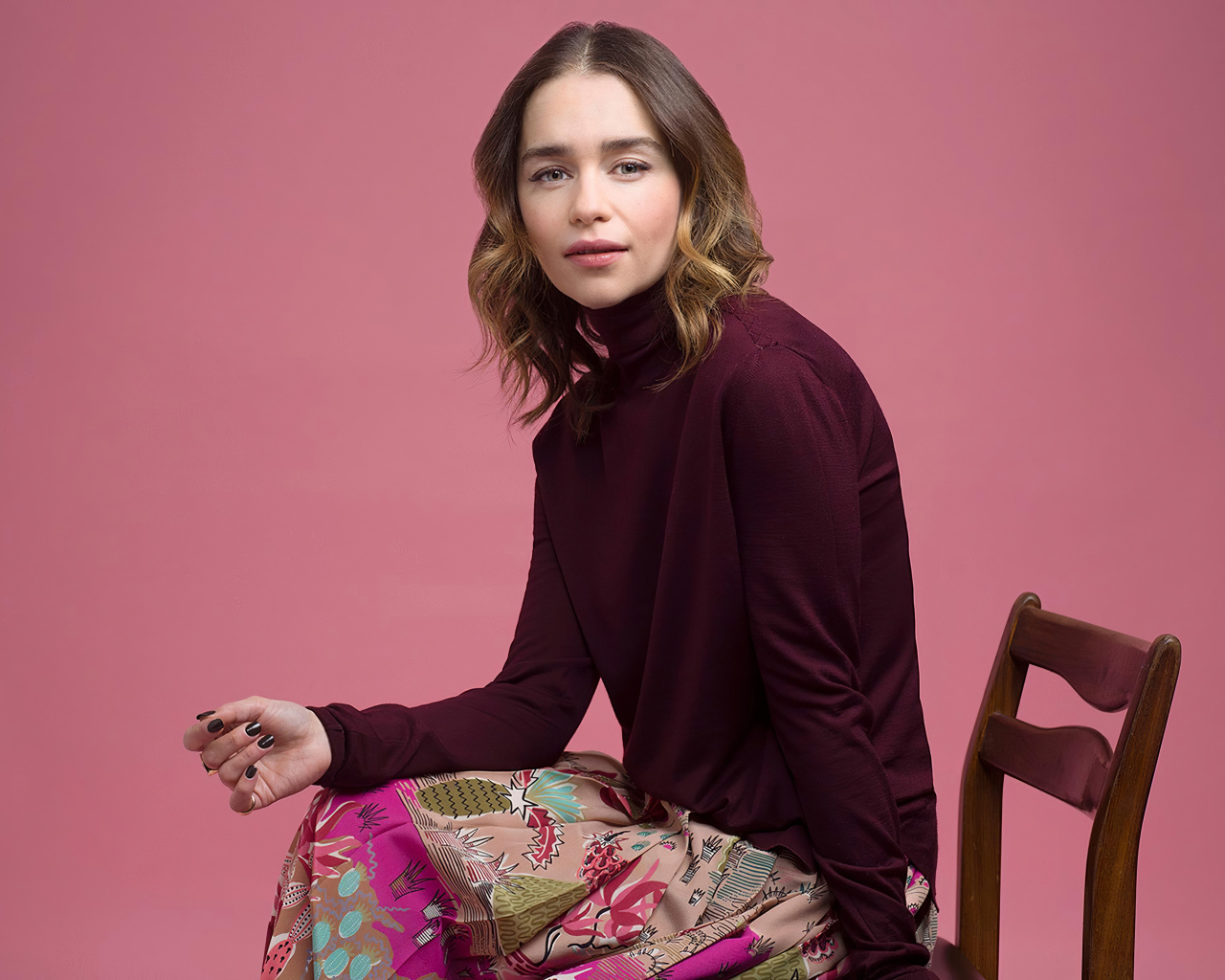 Молодая актриса Эмилия Кларк сидит на стуле