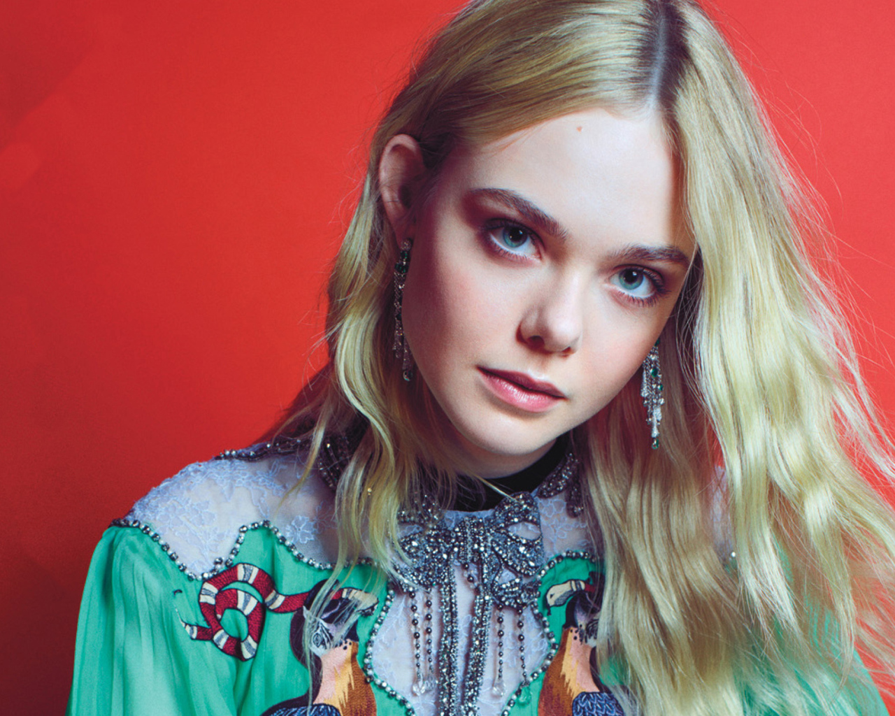 Молодая  блондинка, актриса Эль Фэннинг на красном фоне