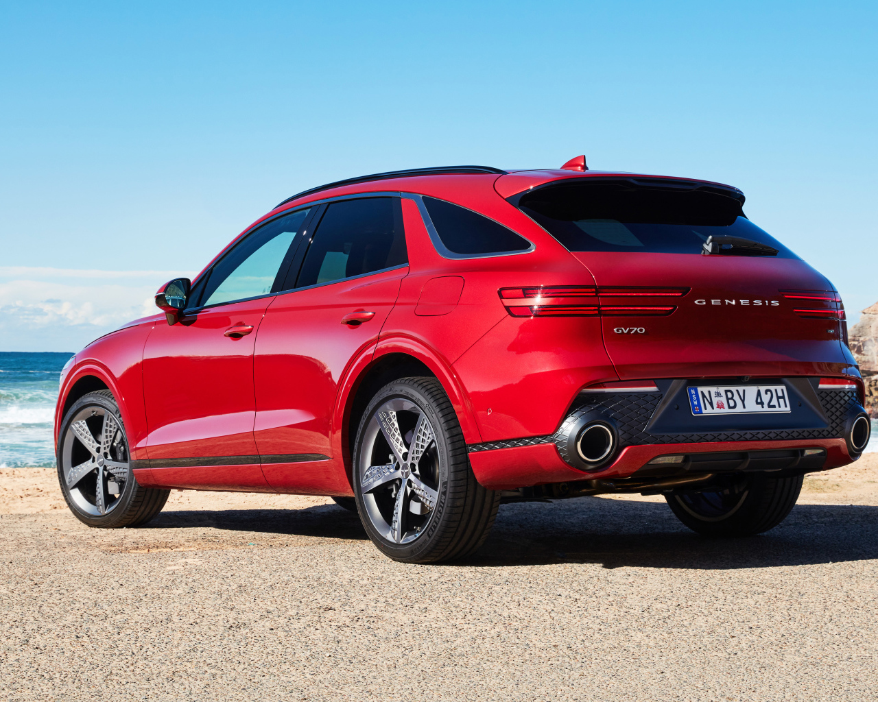 Красный автомобиль Genesis GV70 2.5T AWD 2021 года вид сзади 