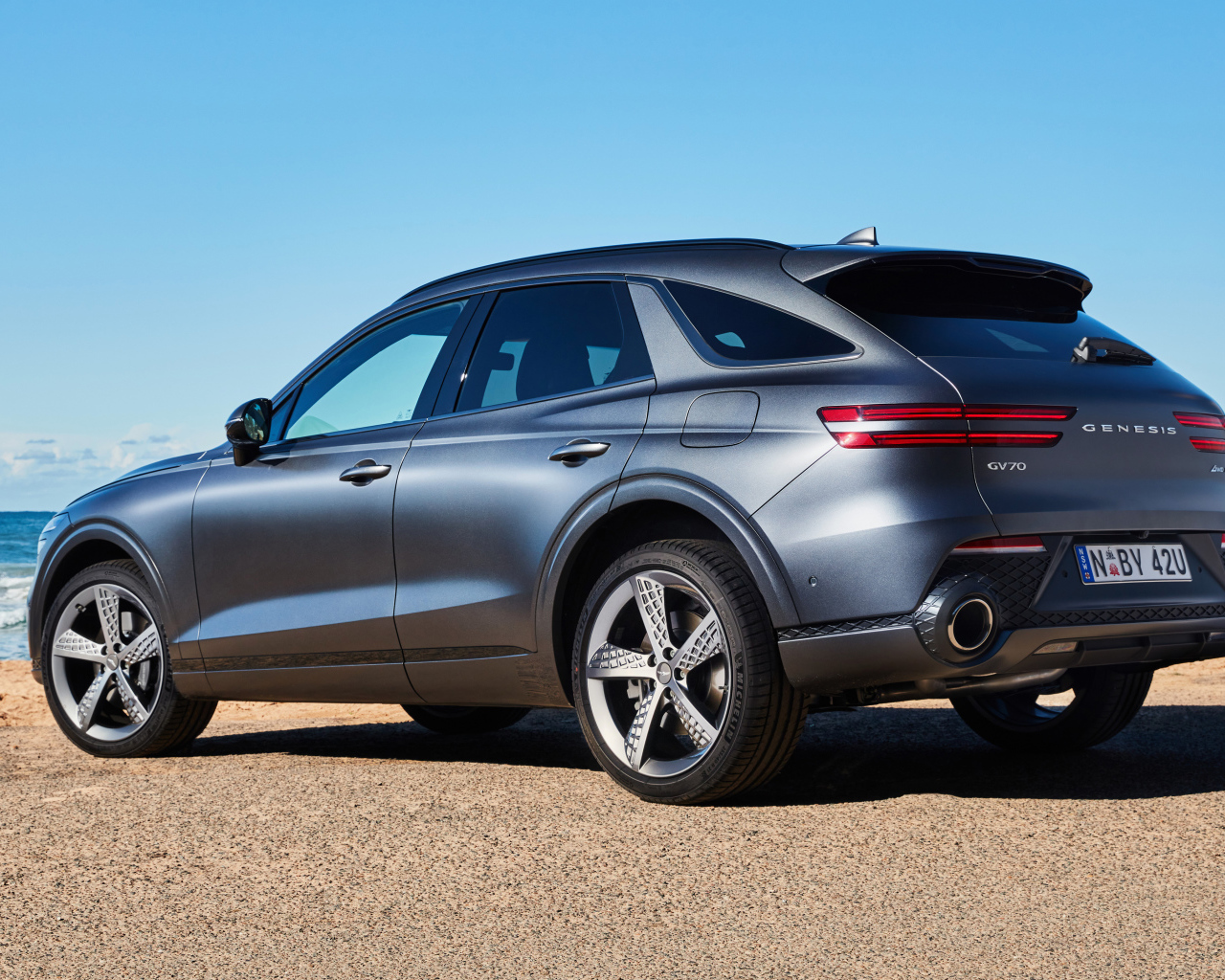 Серебристый автомобиль Genesis GV70 3.5T AWD 2021 года вид сзади 