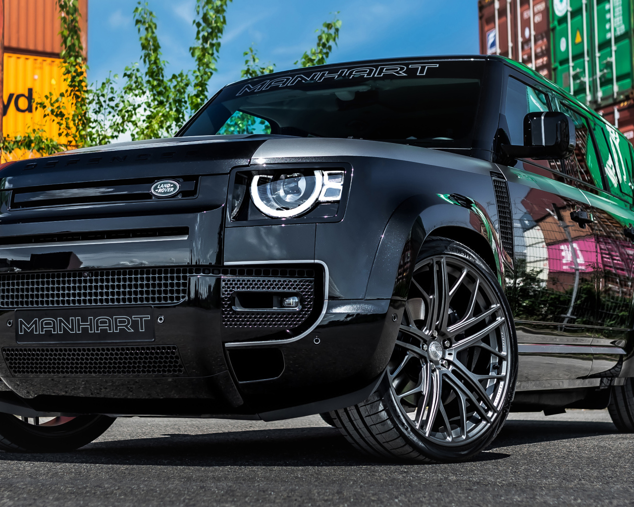 Черный дорогой автомобиль Manhart Defender DP500 2021 года