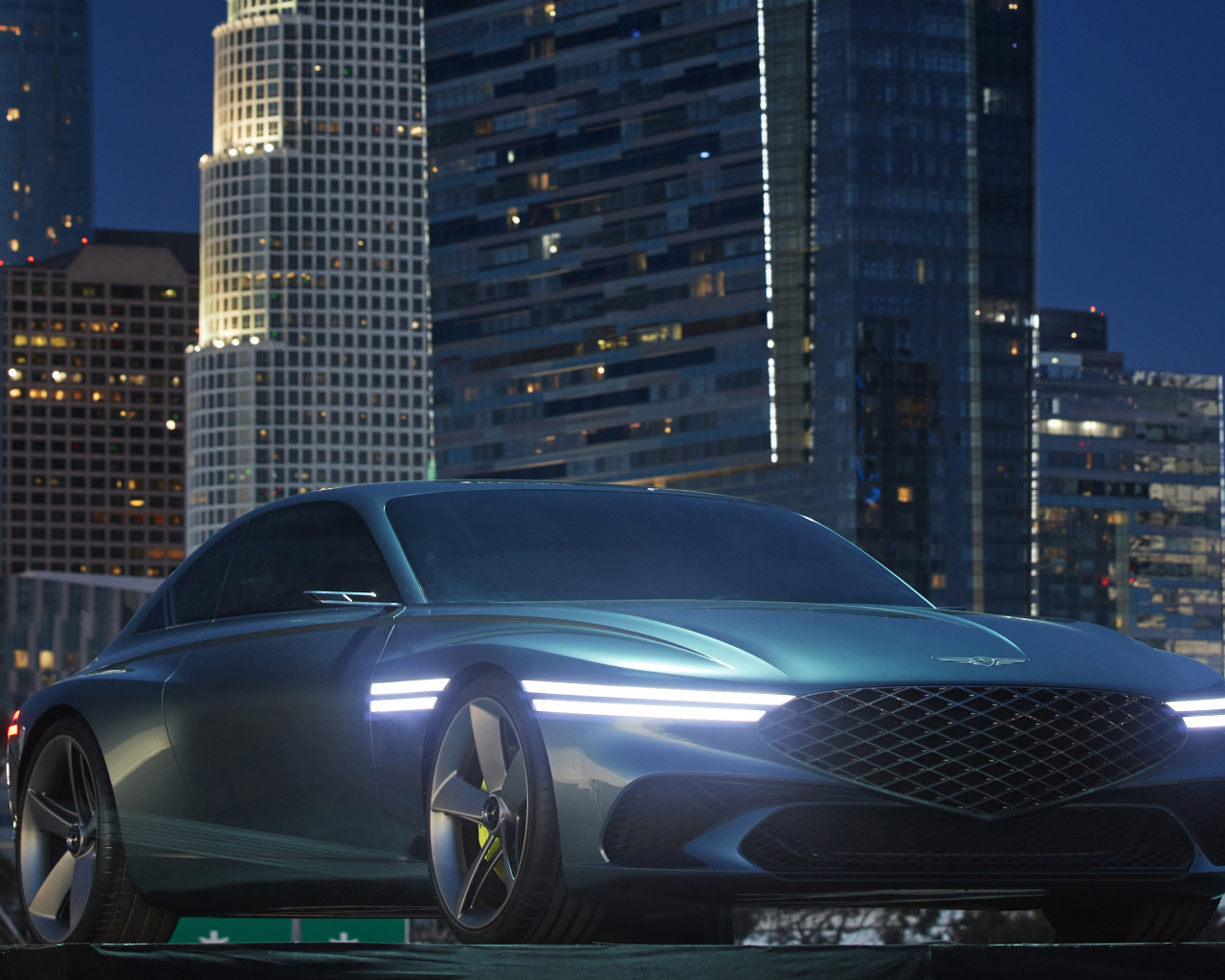 Новый автомобиль Genesis X Concept 2021  года на фоне небоскребов