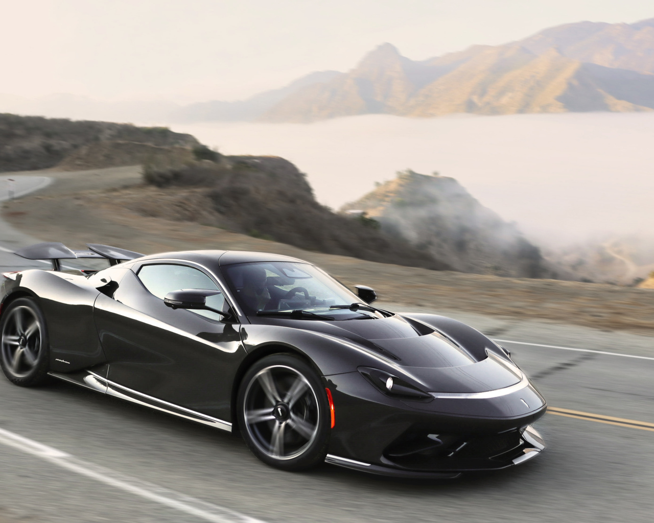 Черный спортивный автомобиль Pininfarina Battista,  2022 года на трассе