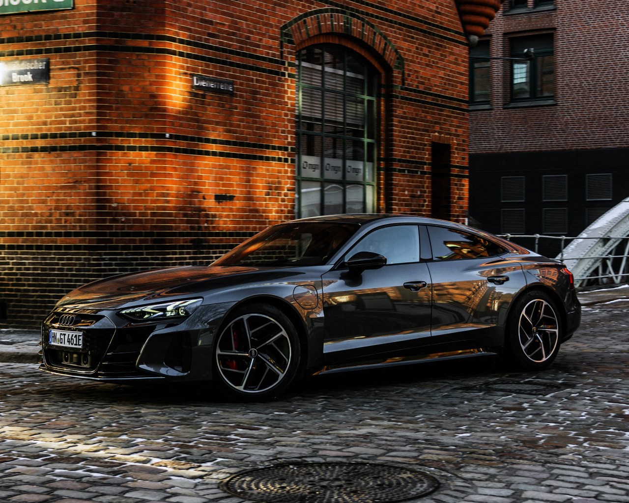 Черный автомобиль Audi RS E-Tron GT 2021 года у здания