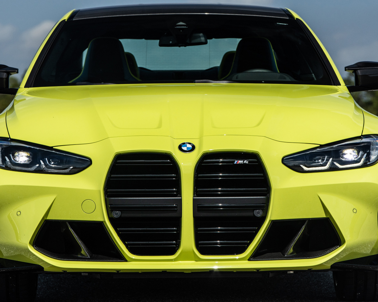 Желтый автомобиль  BMW M4 Coupé 2021 года вид спереди