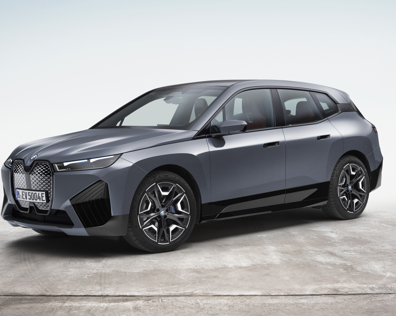 Серебристый внедорожник BMW IX XDrive50 Sport 2021 года на белом фоне