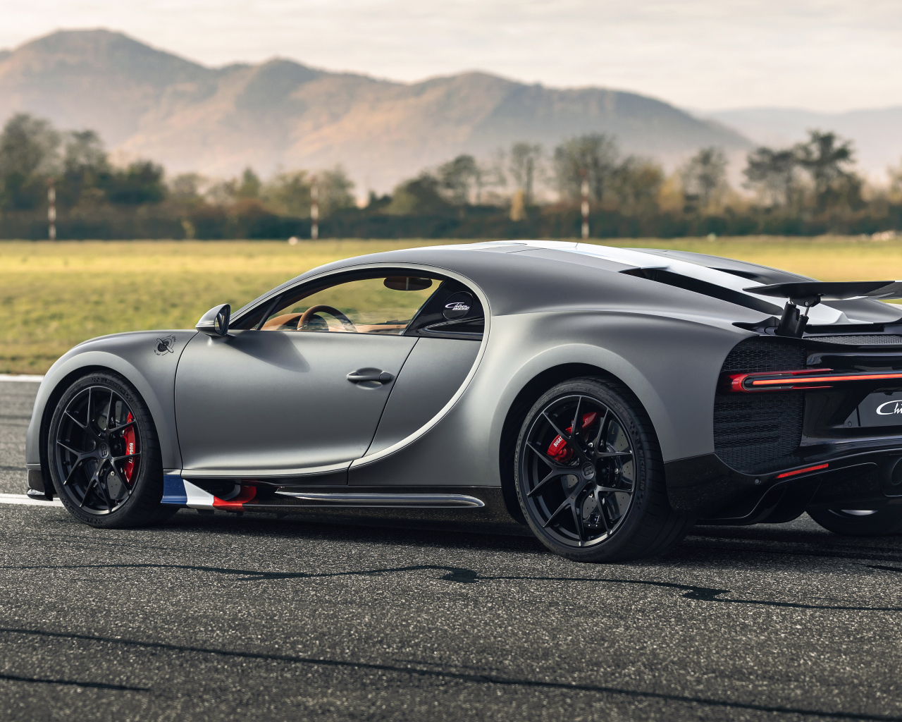 Серебристый спортивный автомобиль Bugatti Chiron  вид сзади