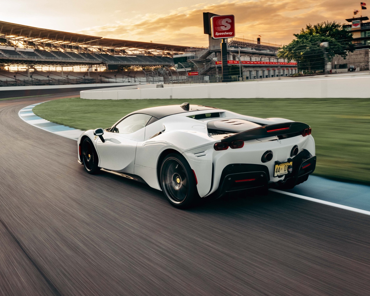 Белый автомобиль  Ferrari SF90 Stradale Assetto Fiorano 2021 года на стадионе