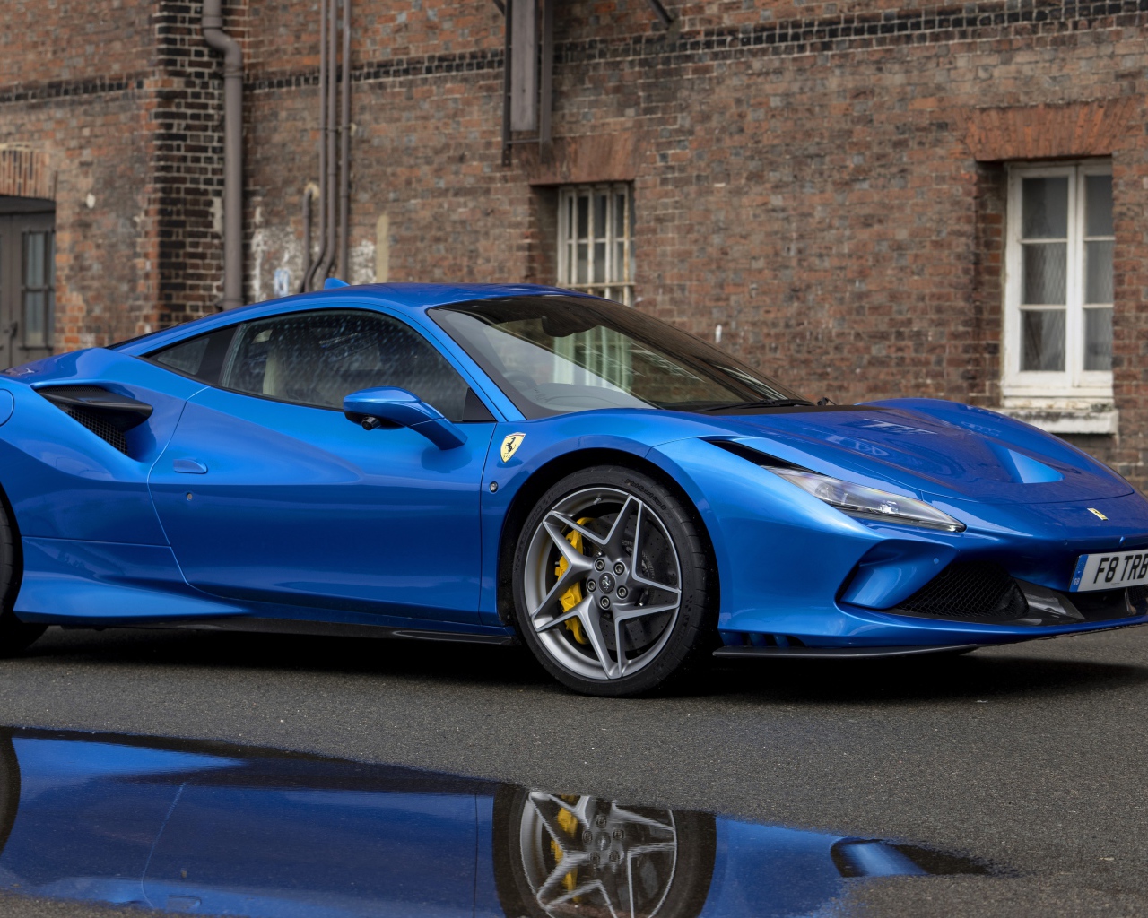 Синий автомобиль Ferrari F8 Tributo у здания