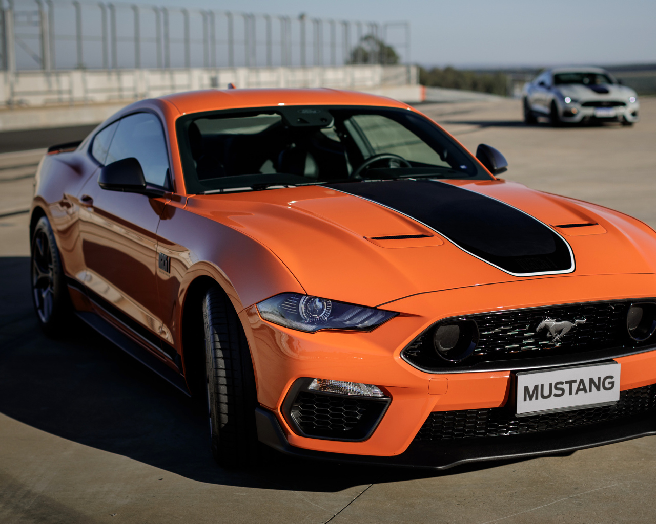 Оранжевый автомобиль Ford Mustang Mach 1 2021 года