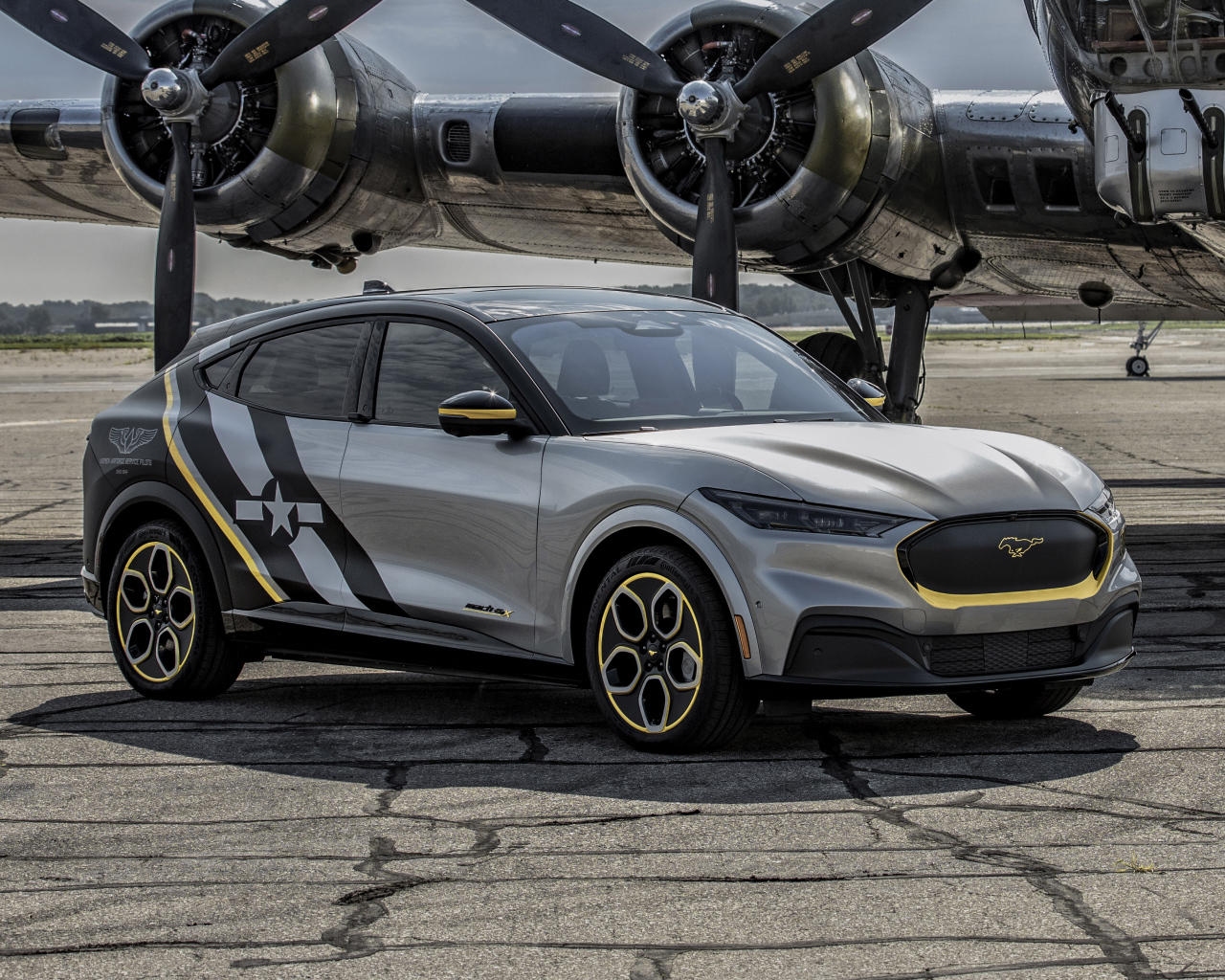 Серебристый Ford Mustang Mach-E, 2021 года у самолета