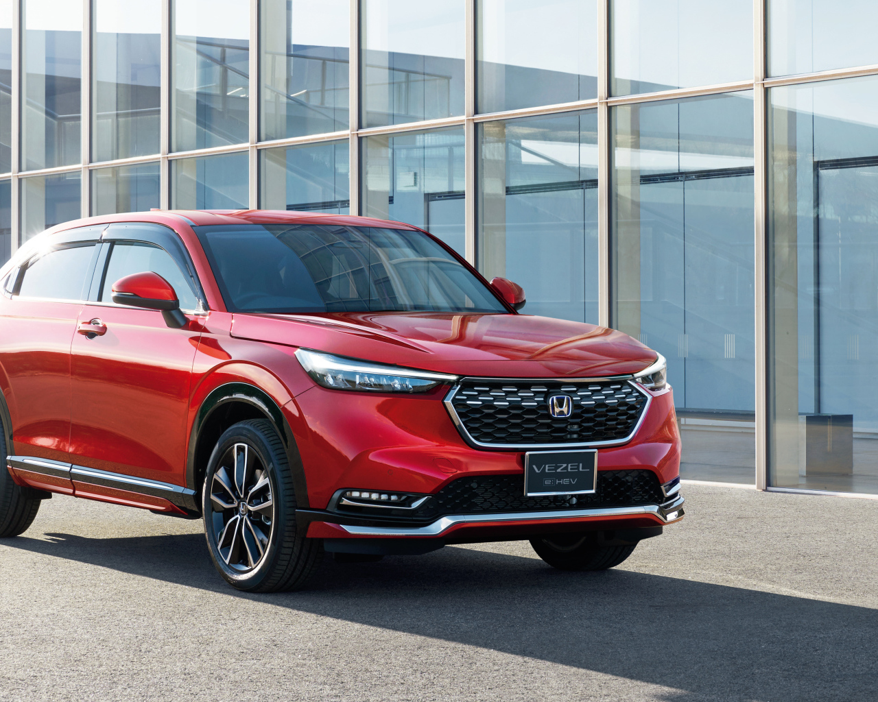Красный автомобиль Honda Vezel EHEV 2021 у здания
