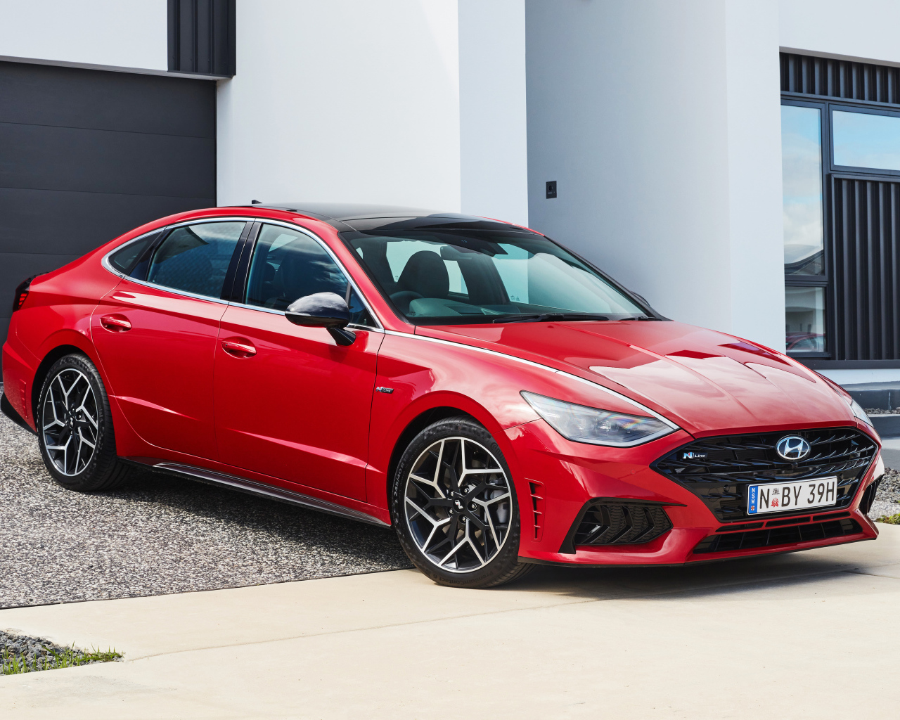 Красный автомобиль Hyundai Sonata N Line 2021 года у гаража