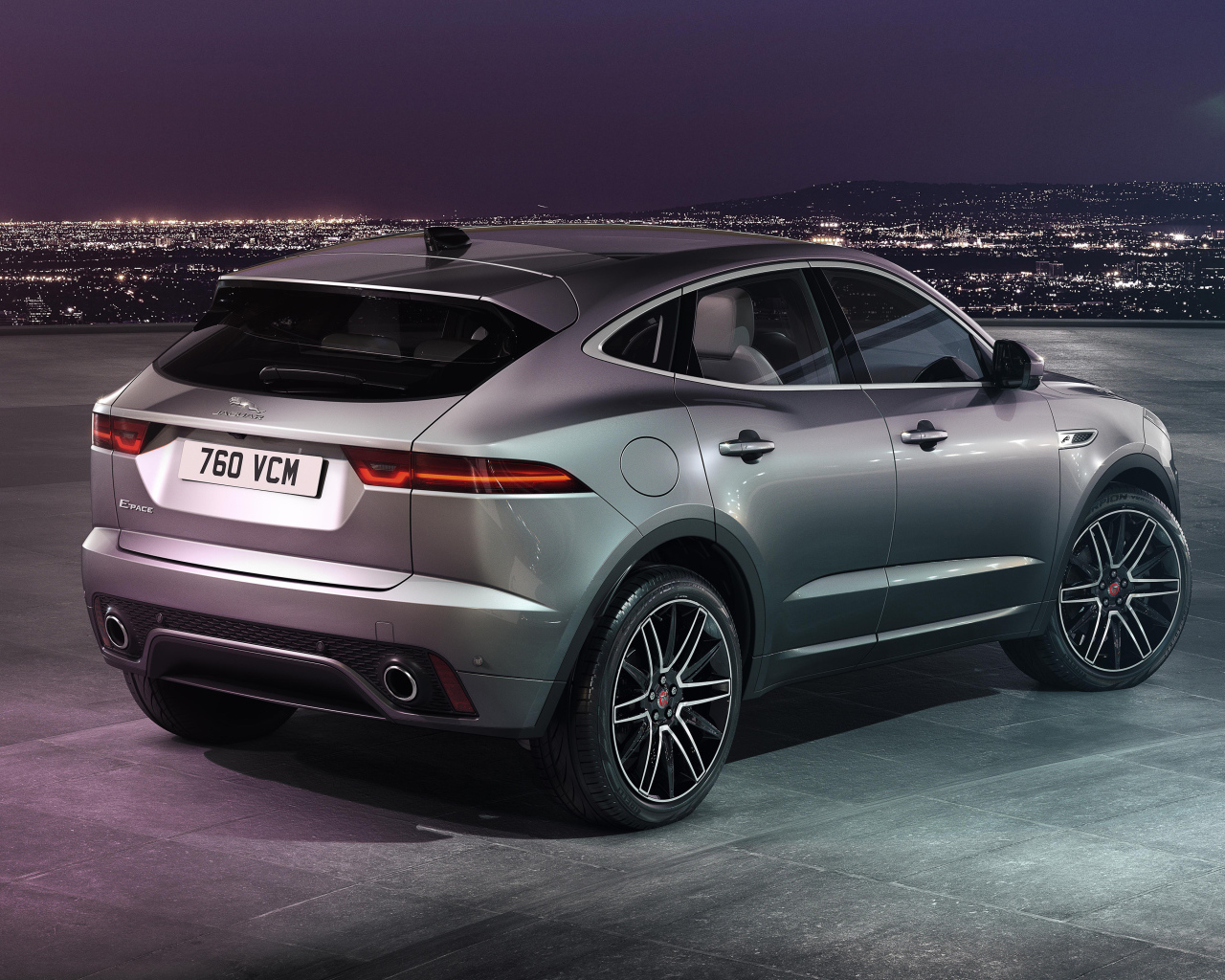 Серебристый Jaguar E-Pace R-Dynamic 2021 года на фоне ночного города