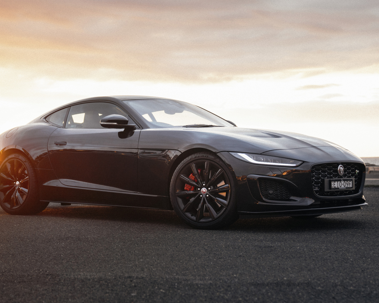 Черный автомобиль Jaguar F-Type R Coupé в лучах солнца