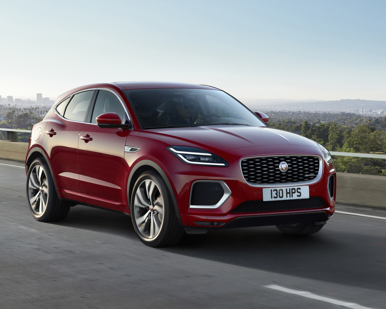 Красный автомобиль Jaguar E-Pace R-Dynamic 2021 года на мосту