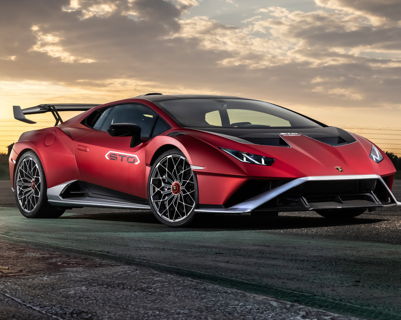 Красный автомобиль Lamborghini Huracán STO 2021 года на фоне неба