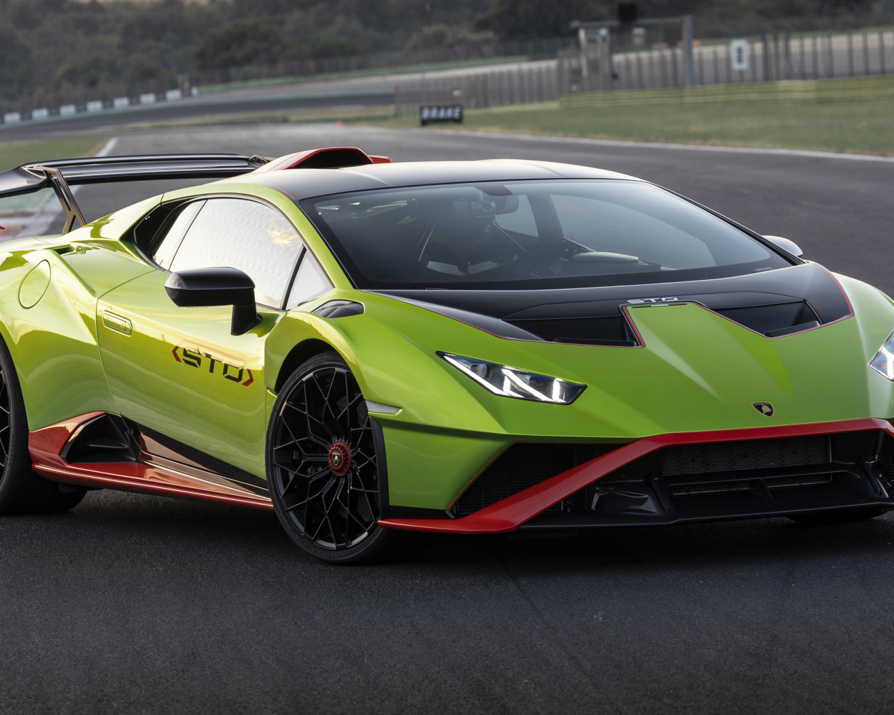 Зеленый автомобиль Lamborghini Huracán STO 2021 года на дороге