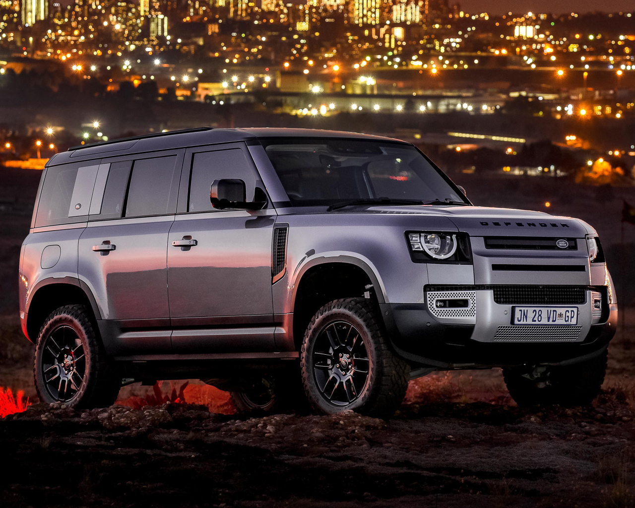 Серебристый внедорожник Land Rover Defender 110 P400 S Urban Pack 2021 года на фоне города