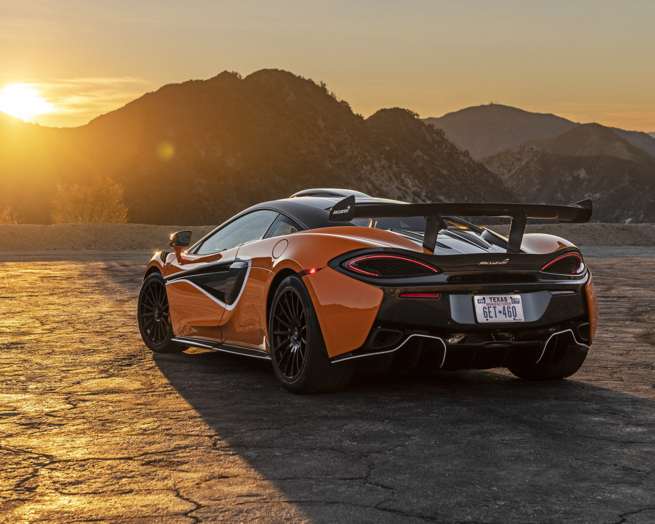 Автомобиль McLaren 620R, 2021 года вид сзади в лучах солнца