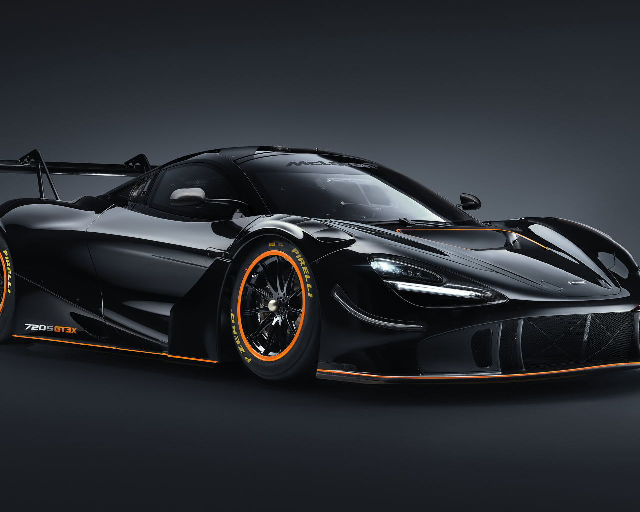 Черный спортивный автомобиль McLaren 720S GT3X 2021 года на сером фоне