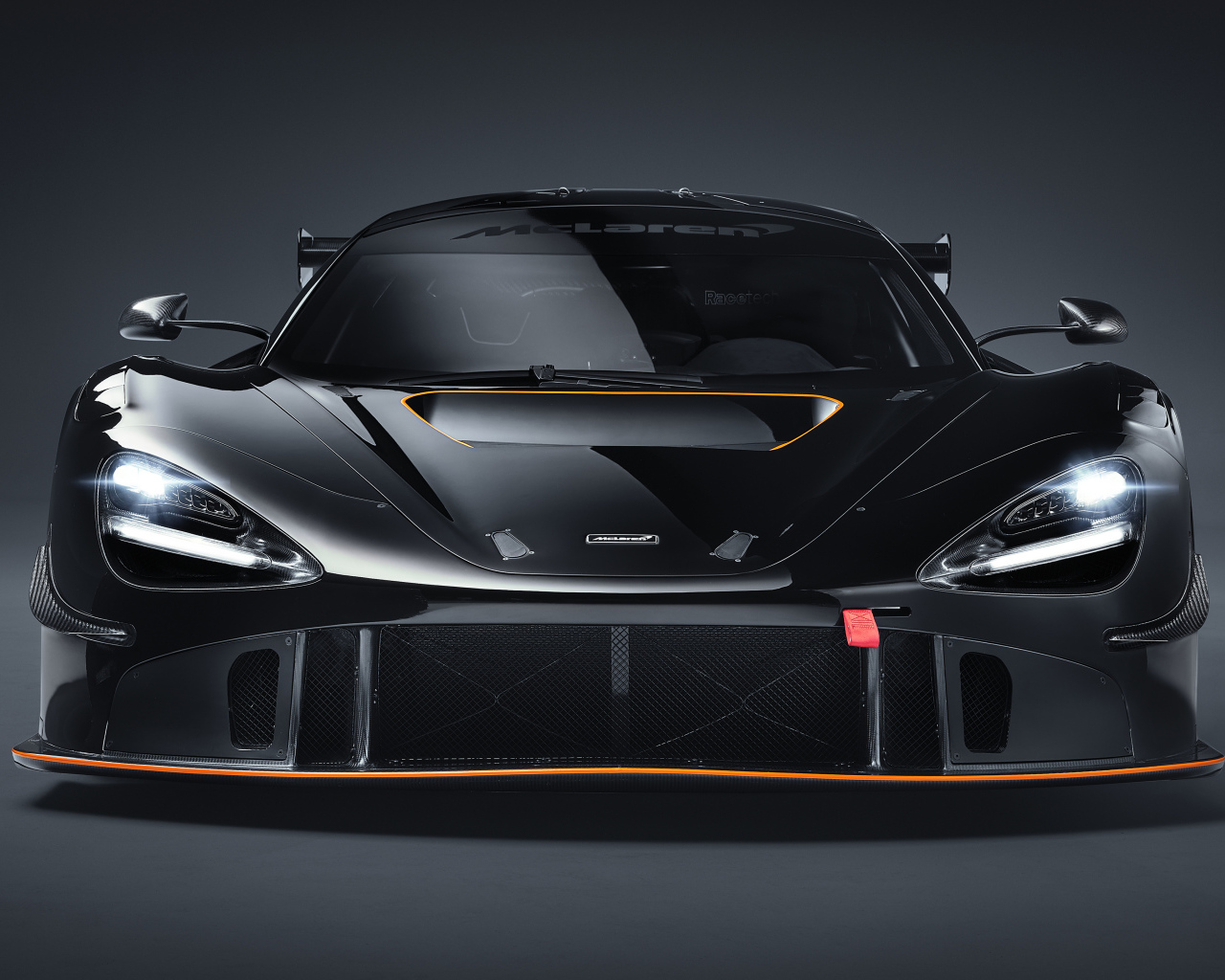 Автомобиль McLaren 720S GT3X 2021 года вид спереди на сером фоне