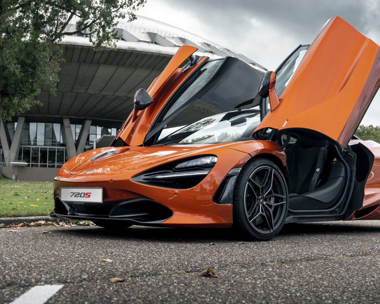 Оранжевый автомобиль McLaren 720S 2021 года с открытыми дверями