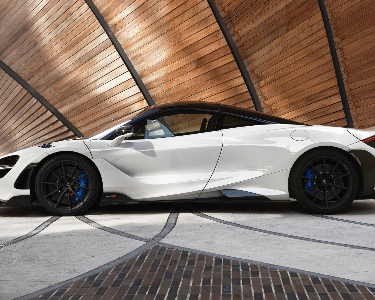 Белый автомобиль  McLaren 765LT, 2021 года вид сбоку