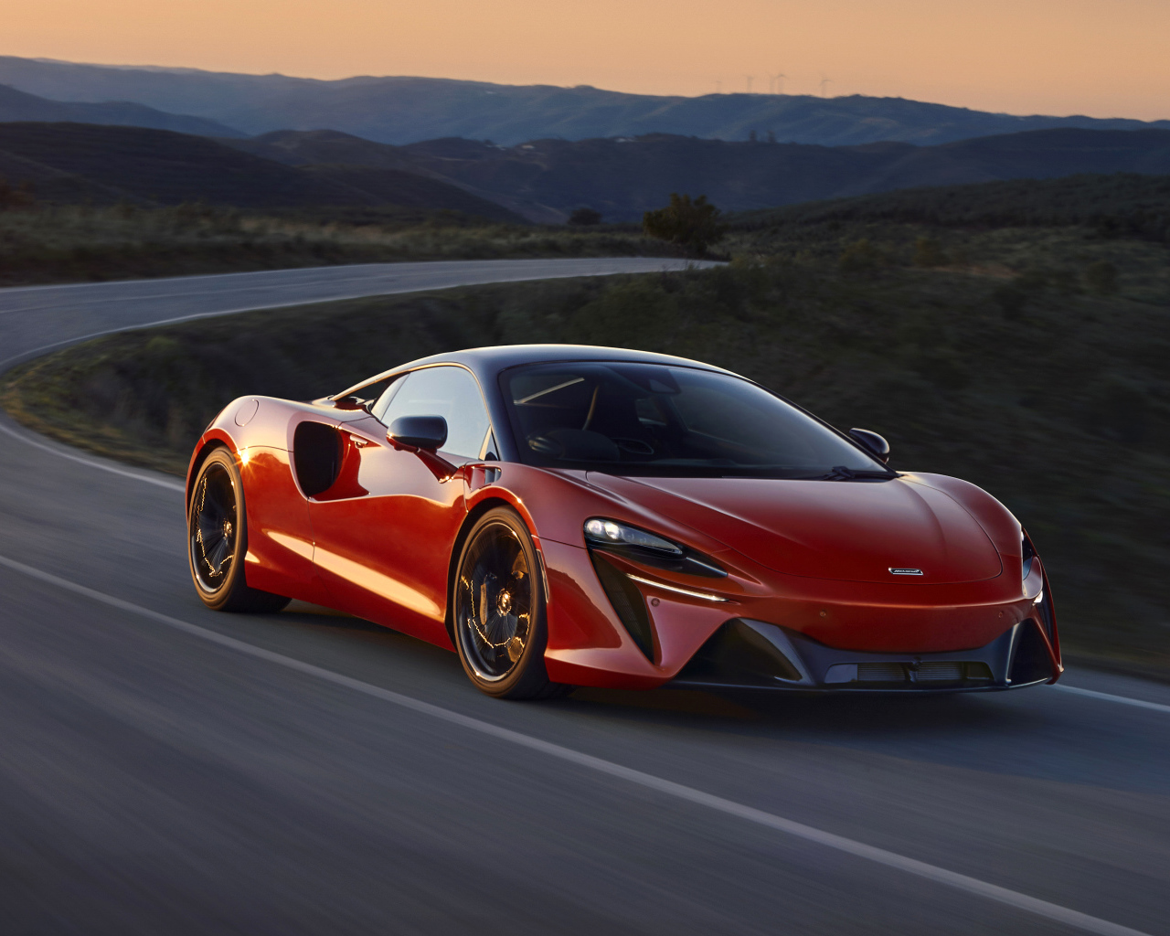 Красный автомобиль McLaren Artura, 2022 года на трассе