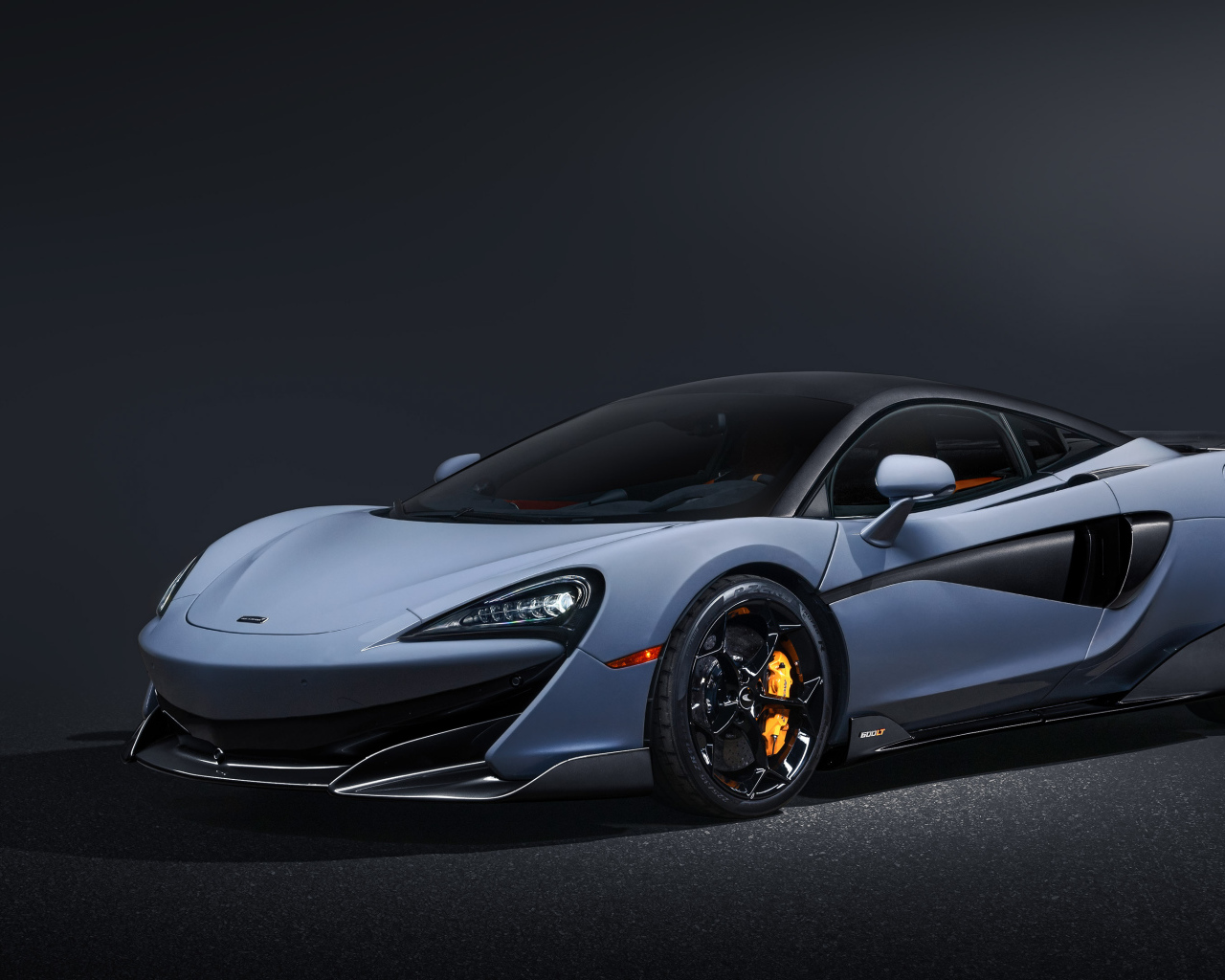 Быстрый автомобиль McLaren 600LT на черном фоне