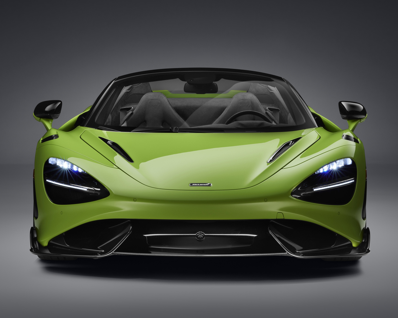 Зеленый McLaren 765LT Spider 2022 года а сером фоне 