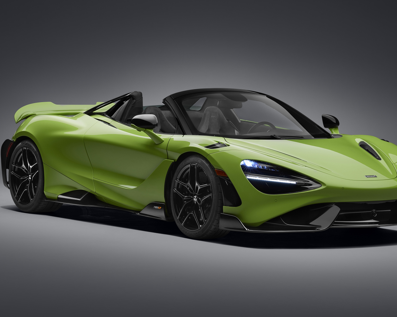 Зеленый автомобиль McLaren 765LT Spider 2022 года на сером фоне