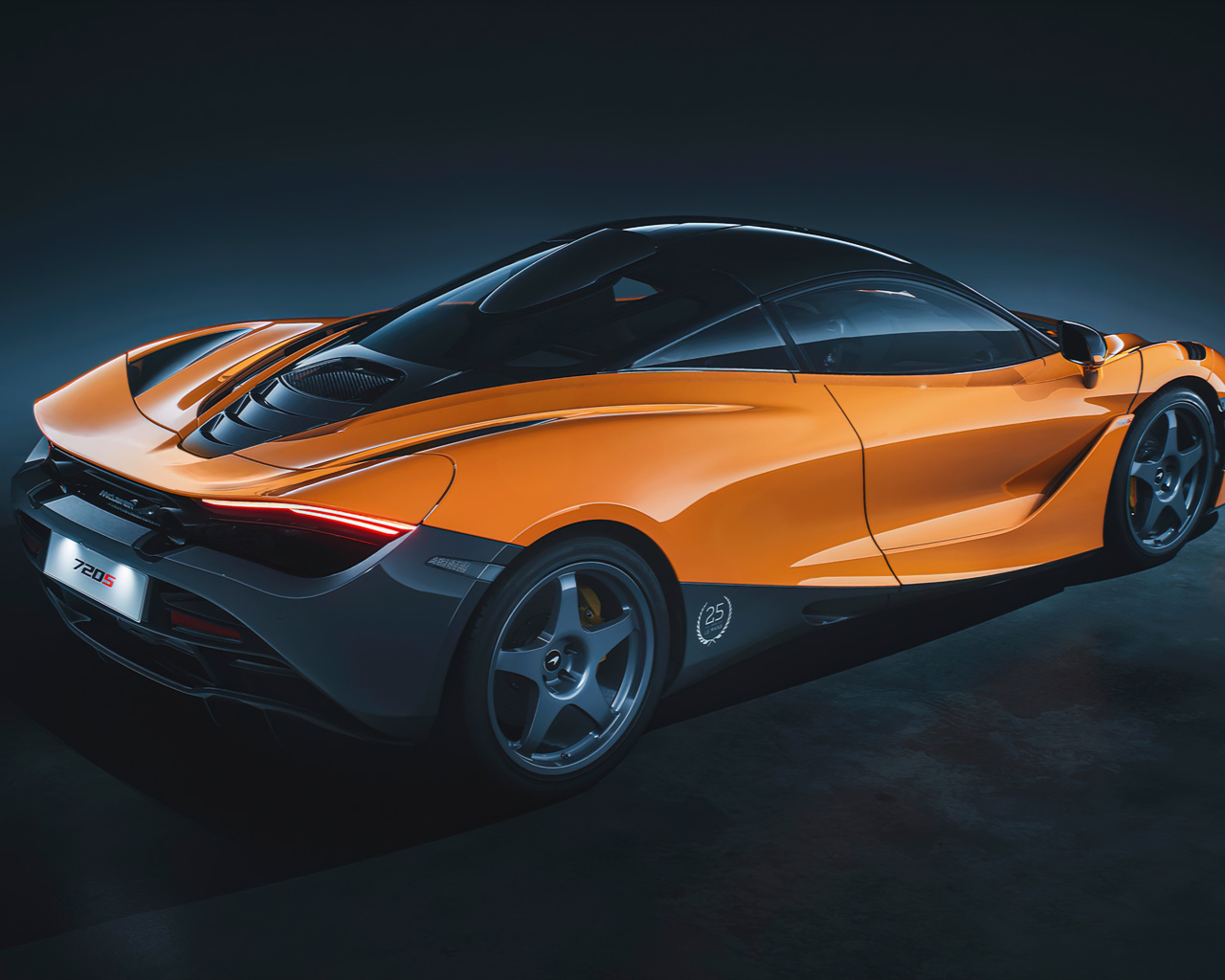 Оранжевый автомобиль McLaren 720S Le Mans вид сзади