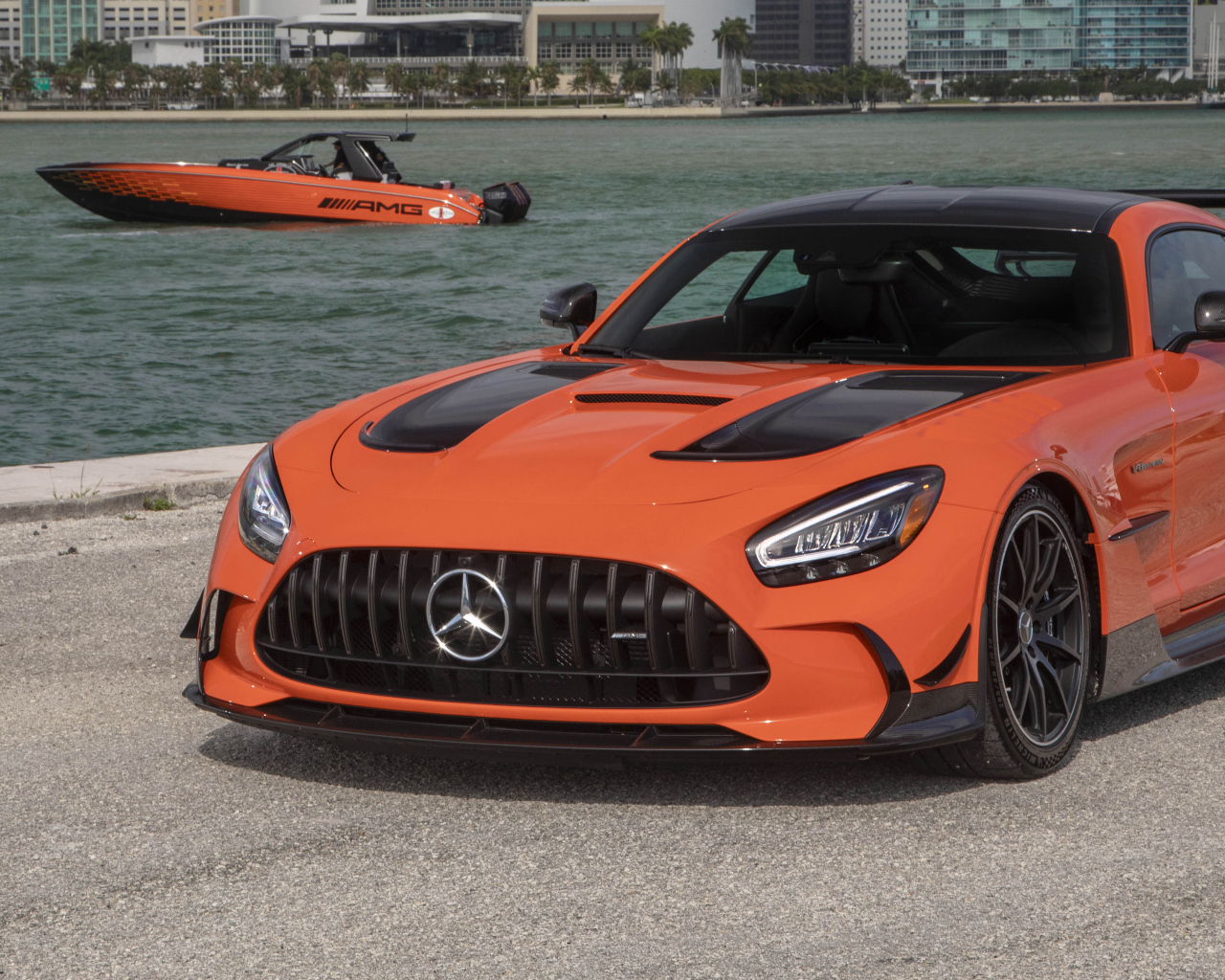 Оранжевый автомобиль Mercedes-AMG GT Black Series 2021 года у воды