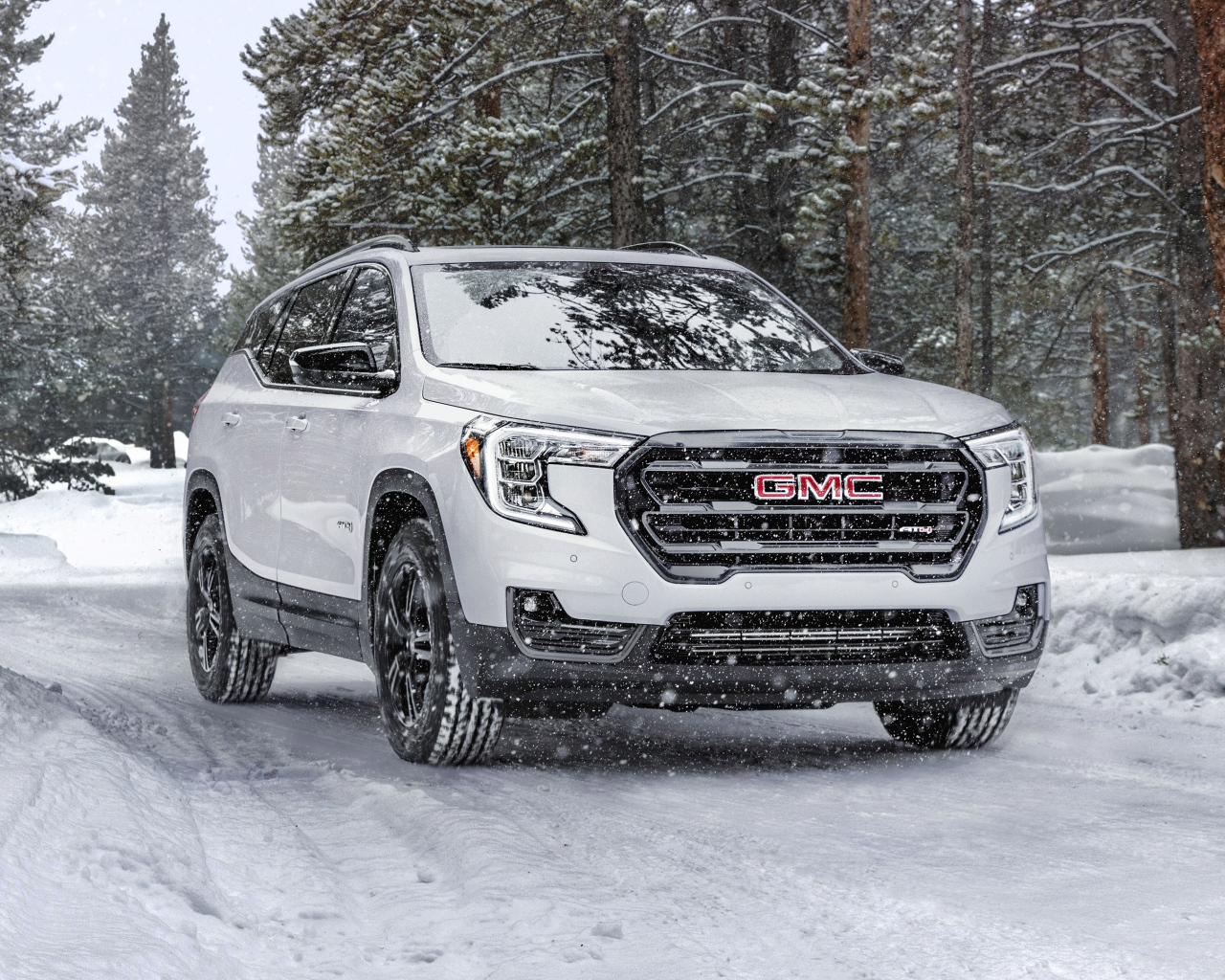 Большой белый внедорожник GMC Terrain AT4, 2022 года на снегу