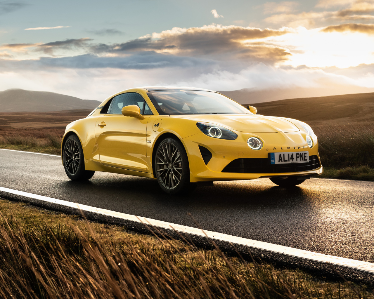Желтый автомобиль Alpine A110, 2021 года на фоне заката