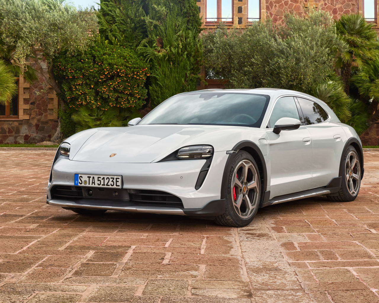 Автомобиль Porsche Taycan 4S Cross Turismo 2021 года у стены