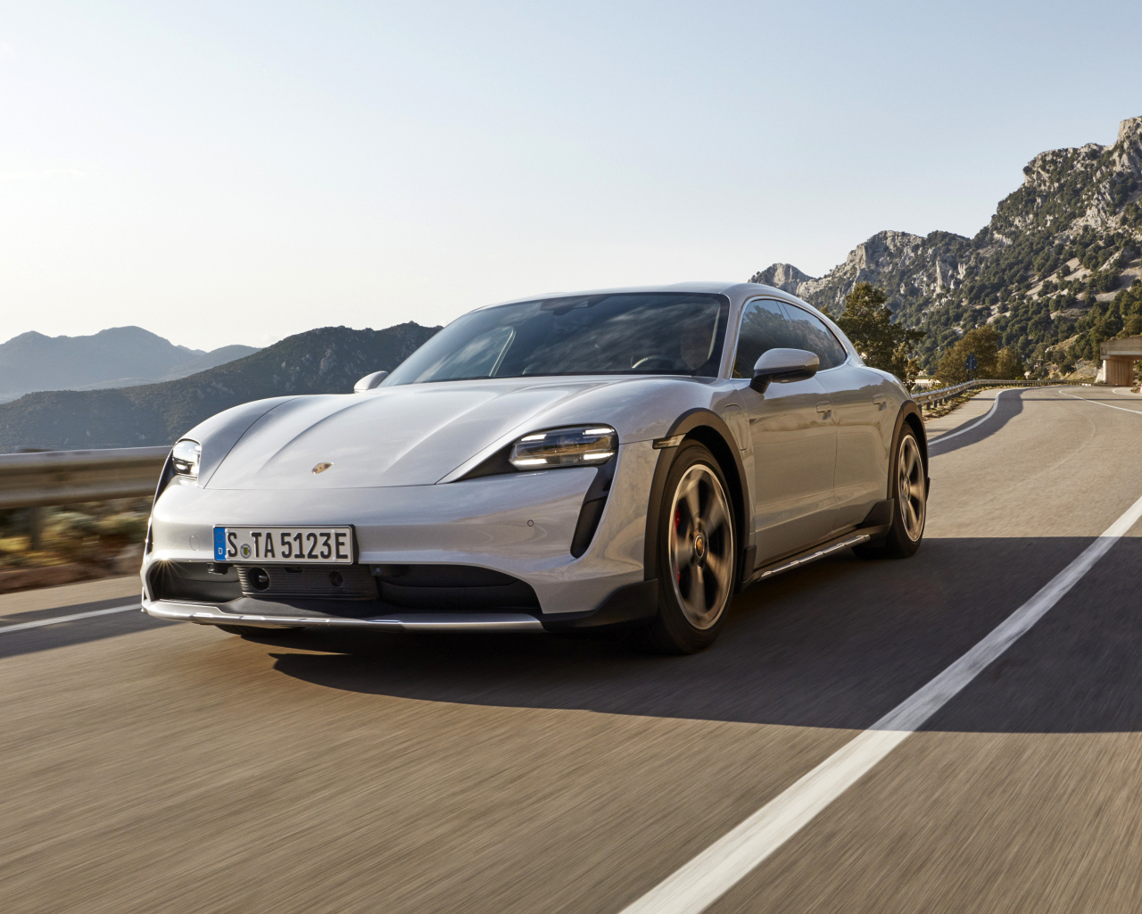 Автомобиль Porsche Taycan 4S Cross Turismo 2021 года на трассе в горах