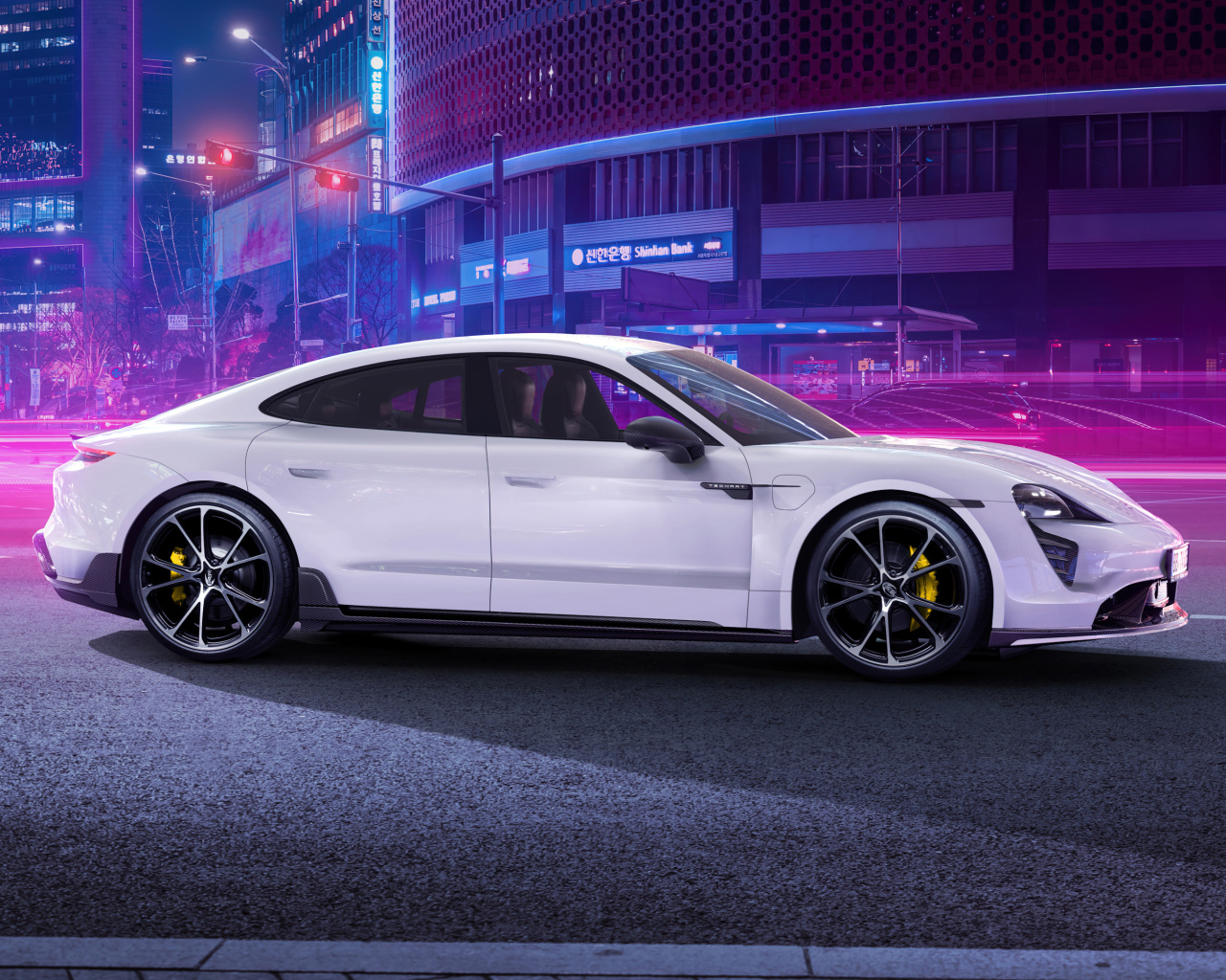 Белый автомобиль Porsche Taycan Aerokit 2021 года в мегаполисе