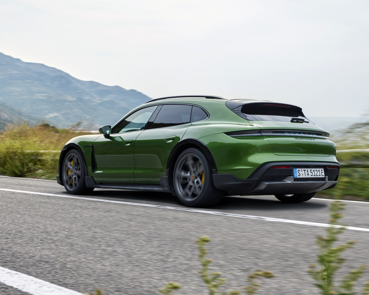 Зеленый автомобиль Porsche Taycan Turbo S Cross Turismo 2021 года вид сзади