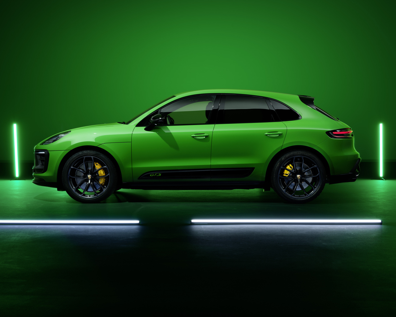 Зеленый автомобиль Porsche Macan GTS Sport Package 2021 года на фоне стены 