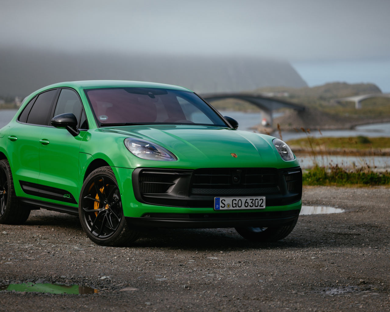 Зеленый автомобиль  Porsche Macan GTS Sport Package 2021 года на фоне моста