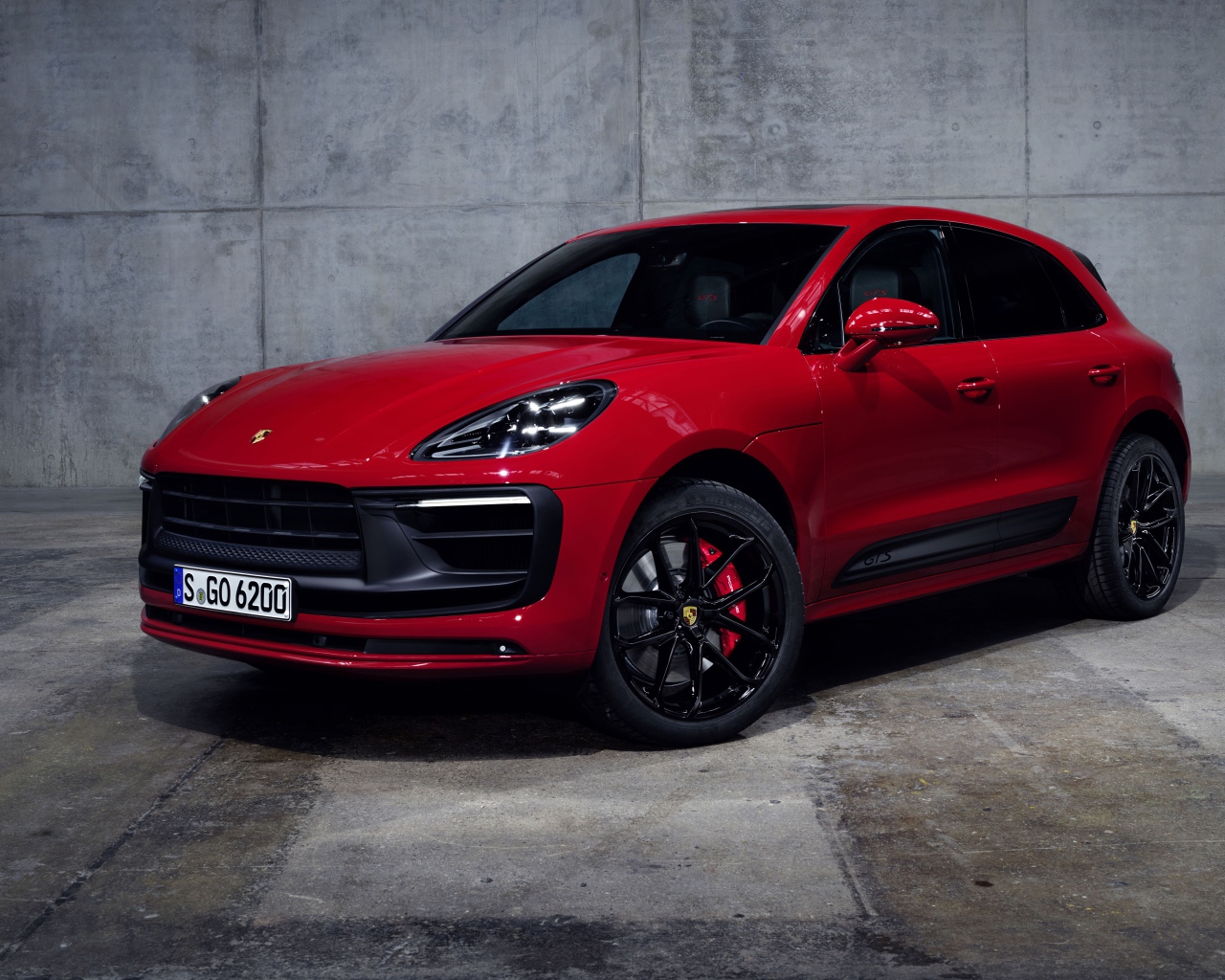 Красный автомобиль Porsche Macan GTS 2021 года на сером фоне