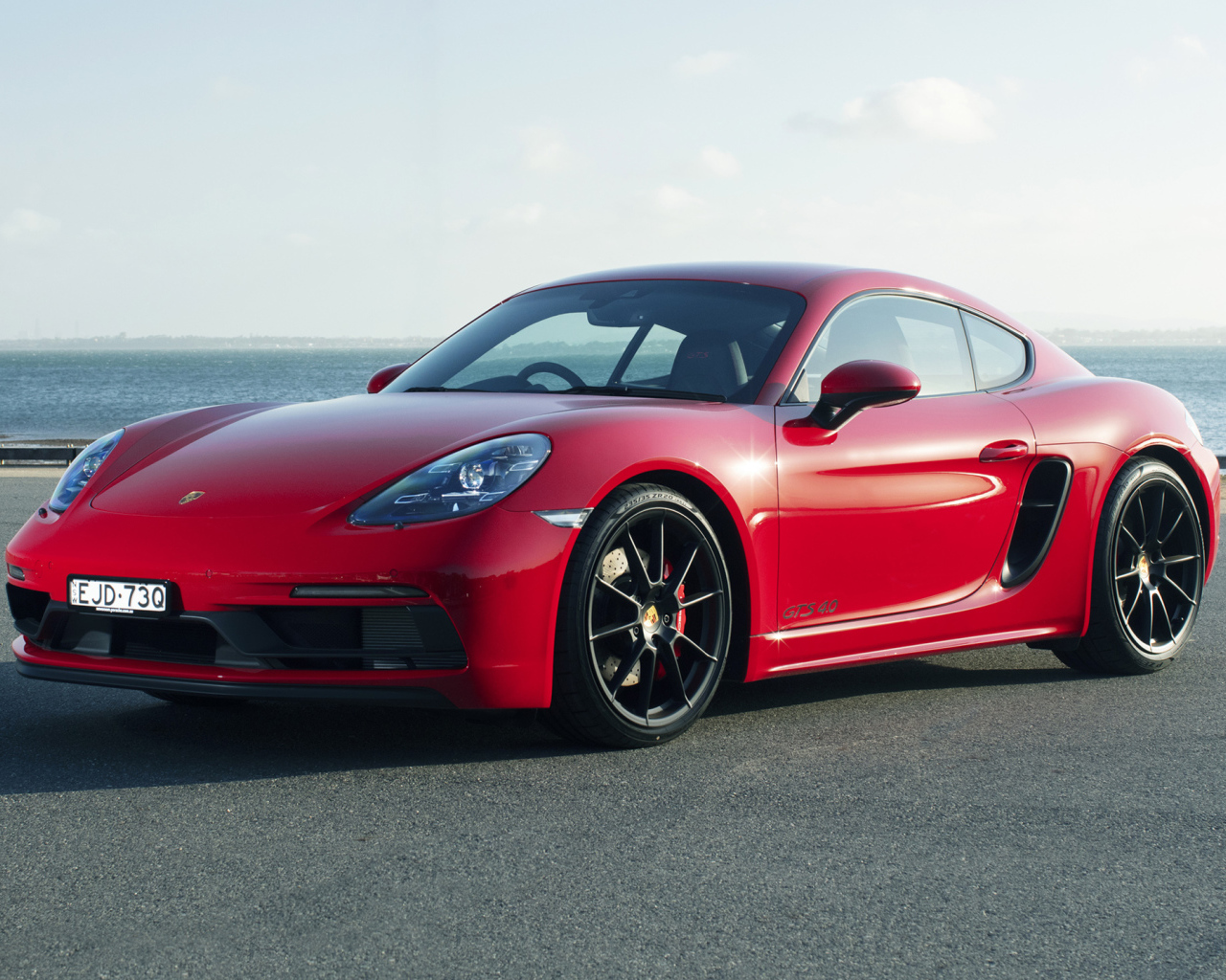 Красный автомобиль Porsche 718 Cayman GTS у моря