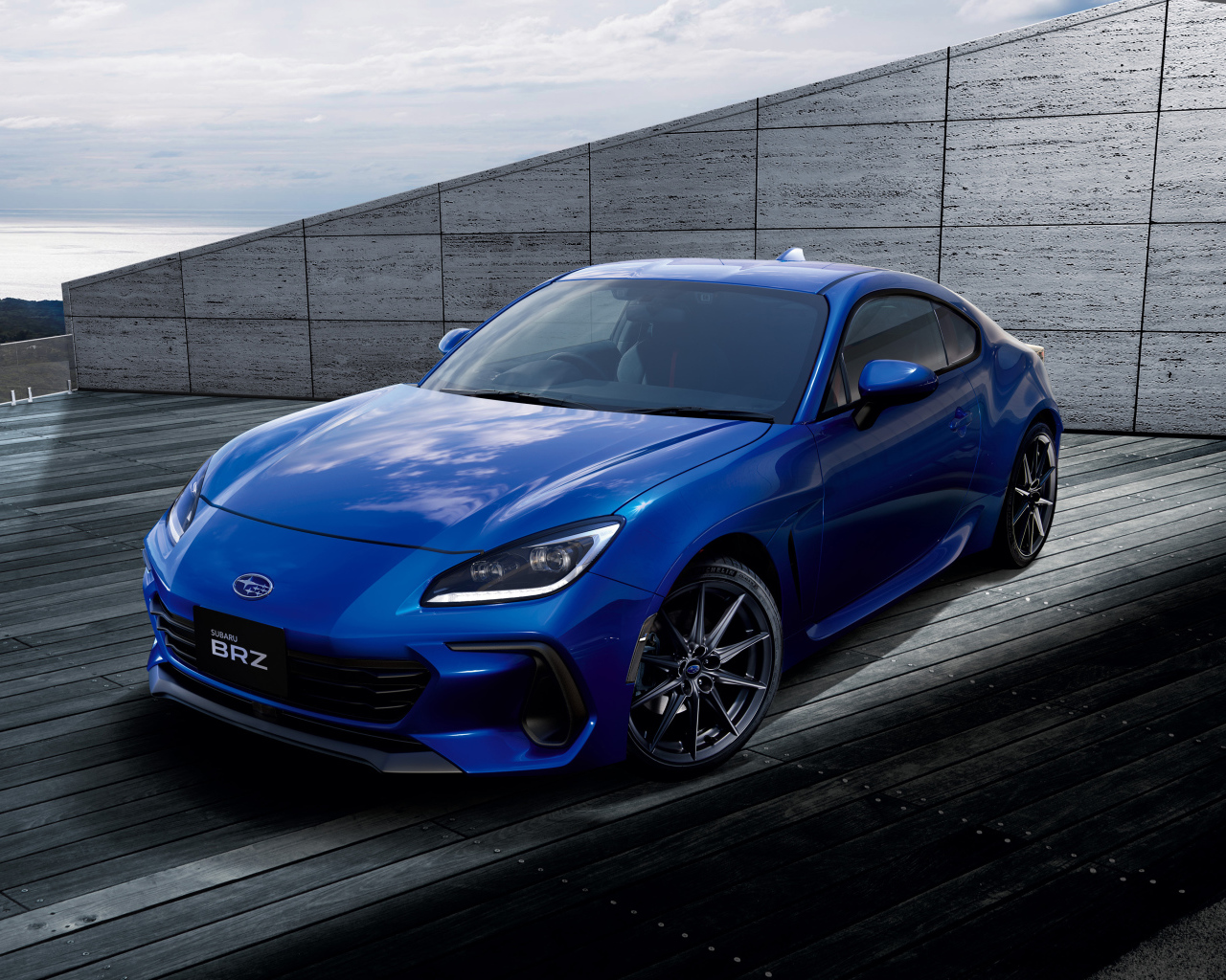 Синий автомобиль Subaru BRZ 2021 года у серой стены